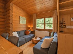 a living room with a blue couch and a table at Chalet in Wörgl near Ski Lift in Hopfgarten im Brixental +30 photos
