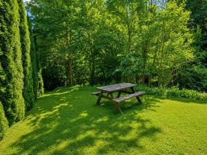 a wooden bench sitting in the grass in a park at Chalet in Wörgl near Ski Lift in Hopfgarten im Brixental