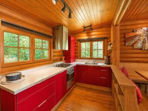 a kitchen with red cabinets and a wooden ceiling at Chalet in Wörgl near Ski Lift in Hopfgarten im Brixental
