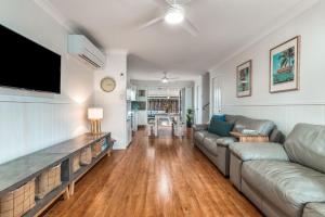 a living room with a couch and a flat screen tv at 1-41 Park Street in Evans Head