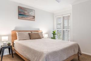 a white bedroom with a bed and a window at 1-41 Park Street in Evans Head +11 photos