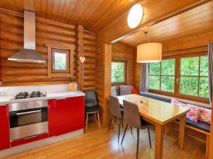 a kitchen with red cabinets and a table with chairs at Rustic chalet near SkiWelt Wilder Kaiser in Salvenberg