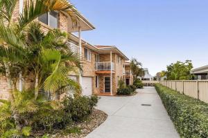a house with a palm tree next to a sidewalk at 1-41 Park Street in Evans Head