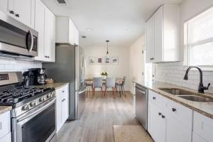 a kitchen with white cabinets and a stove top oven at Remodeled 4BR 2BA Steps from Georgetown Square in Georgetown