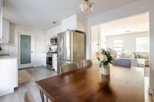 a kitchen and living room with a wooden table and a refrigerator at Remodeled 4BR 2BA Steps from Georgetown Square in Georgetown