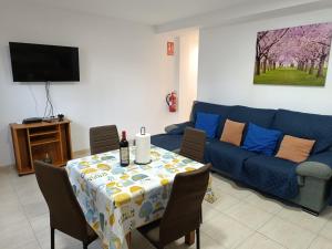 a living room with a table and a blue couch at paraiso soleado in Tazacorte