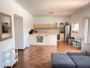 a kitchen with white cabinets and a couch in a room at Villa Canyon Escape 12 Personen in Bilišane