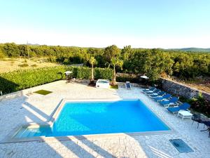 a swimming pool in a yard with chairs and trees at Villa Canyon Escape 12 Personen in Bilišane