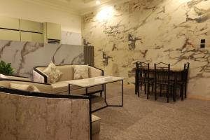 a living room with a couch and a table at إطلالة السيب للشقق المخدومة Itlalat Alseeb Serviced Apartments in Khafji