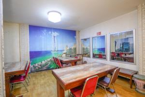 a dining room with tables and chairs and a mural at RedDoorz at Gangnam Hotel near Mall Olympic Garden in Betek