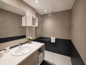 a bathroom with a sink and a mirror at The Originals Résidence, Les Strélitzias in Juan-les-Pins +32 photos