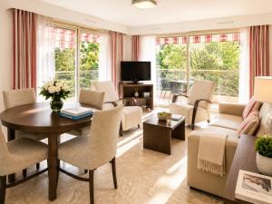 a living room with a table and chairs at The Originals Résidence, Les Strélitzias in Juan-les-Pins