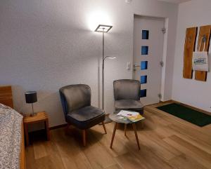 a room with two chairs and a table and a bed at Ferienglück Unterkirnach in Unterkirnach