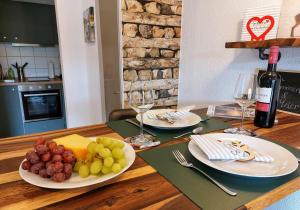 a table with two plates of grapes and a bottle of wine at Ferienglück Unterkirnach in Unterkirnach