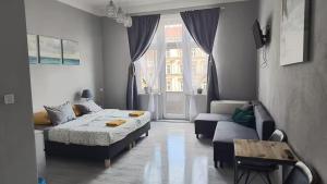 a bedroom with two beds and a couch and a window at Colourful Rooms Wrocław in Wrocław +30 photos