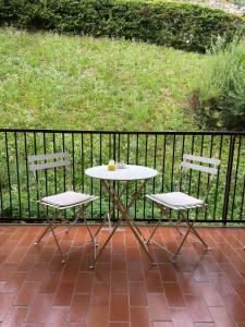 a table and two chairs sitting next to a fence at Frenk house over Varenna in Perledo