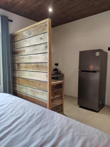 a room with a bed and a refrigerator in it at Dothalu Villa in Ahangama