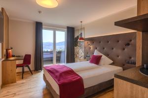 a hotel room with a bed and a desk and a window at Hotel Haberl - Attersee in Attersee am Attersee +79 photos