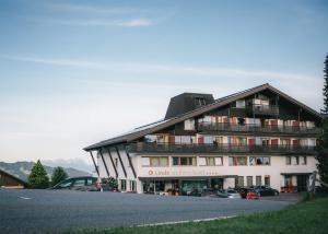 a large building with cars parked in front of it at Wellnesshotel Linde in Sulzberg