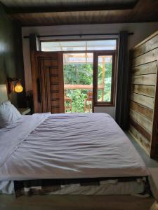 a bedroom with a large bed and a window at Dothalu Villa in Ahangama