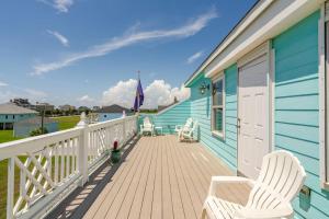 a blue house with two white chairs on a deck at 3 King Suites 15 Guests - Sunzout in Bolivar Peninsula