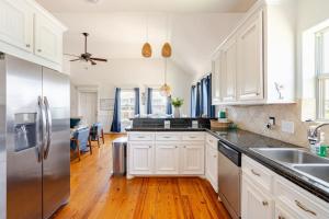 a kitchen with white cabinets and a stainless steel refrigerator at 3 King Suites 15 Guests - Sunzout in Bolivar Peninsula