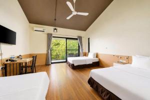 a hotel room with two beds and a desk at An Binh Village in Yên Bình