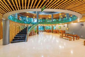 a lobby with a staircase and tables and chairs at An Binh Village in Yên Bình