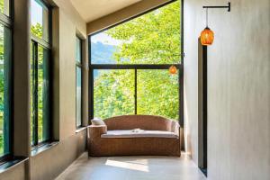 a wicker chair in a room with a large window at An Binh Village in Yên Bình