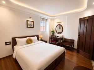 a bedroom with a large bed and a desk at Hanoi Luxury Hotel - Old Quarter in Hanoi +28 photos
