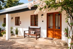 a porch with a bench and a wooden door at Cedar Stay Clanwilliam in Clanwilliam