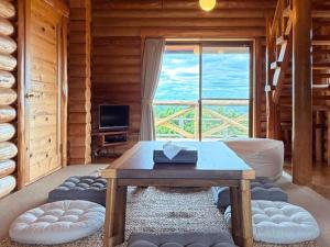 a living room with a table and a large window at Maruta ひたち大宮 in Takabu