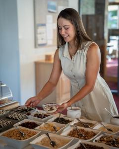 a woman standing in front of a buffet of food at Wellnesshotel Linde in Sulzberg