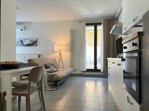 a kitchen and living room with a table and a couch at Suite Terrazza Mazzini in Molinella