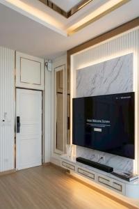 a living room with a large flat screen tv on a wall at Maha Sarakham Residence Hotel in Maha Sarakham +3 photos