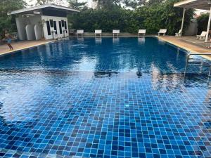 a large swimming pool with blue tiles on it at Niruan apartment in Pattaya