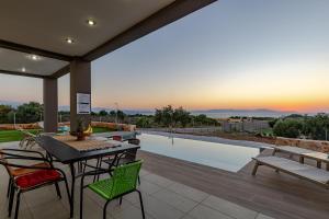 a patio with a table and chairs and a pool at GOLD DREAM HOME in Agios Onoufrios