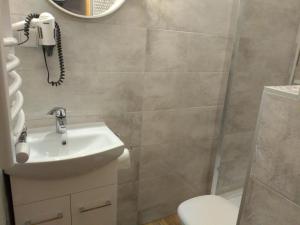 a bathroom with a sink and a phone on the wall at Dom Wypoczynkowy U Chramca in Białka Tatrzańska