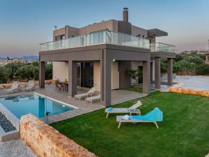a villa with a swimming pool and a house at GOLD DREAM HOME in Agios Onoufrios