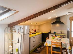 a kitchen with a table and a refrigerator at Casa Evita in Sanxenxo