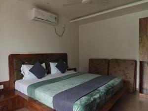 a bedroom with a large bed with blue pillows at The Metro Hotel in Panhāla