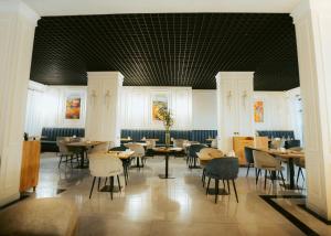 a dining room with tables and chairs and a ceiling at Baden-Baden Hotel Tashkent in Tashkent