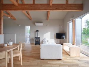 a living room with a white couch and a table at Adagio Retreat Tokachidake in Biei