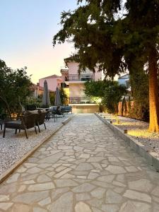 a stone walkway with benches and a tree at The Residence Myrina in Myrina