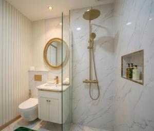 a bathroom with a shower and a toilet and a sink at Roi Et Residence Hotel in Roi Et +3 photos