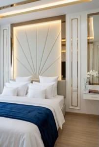 a large white bed with white pillows in a room at Roi Et Residence Hotel in Roi Et