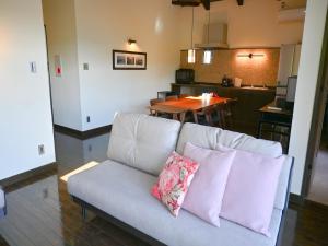 a living room with a couch with two pillows at エンゼルグランヴィラ由布院 in Yufu +16 photos