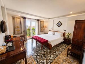 a bedroom with a large white bed and a red bench at Hanoi Luxury Hotel - Old Quarter in Hanoi