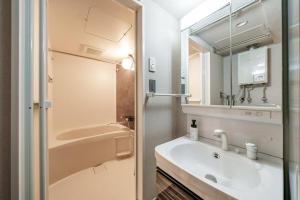a bathroom with a sink and a mirror at Lotus south in Sapporo