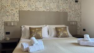 a bedroom with a large bed with two pillows at Hotel Paradiso 1972 in Schiavonea